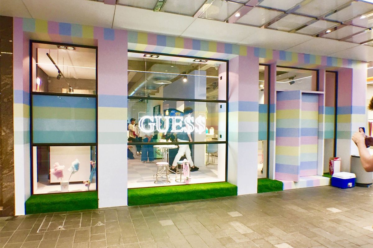 GUESS storefront takeover with a pastel-striped facade