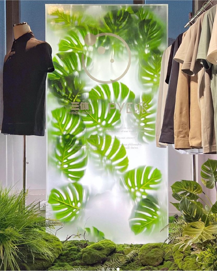 PYE window: frosted panel with layered monstera leaves and a moss bed